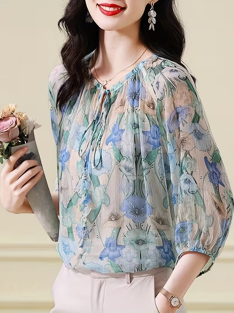 This ethereal Top features a delicate floral print in  of blue, green, and beige Top