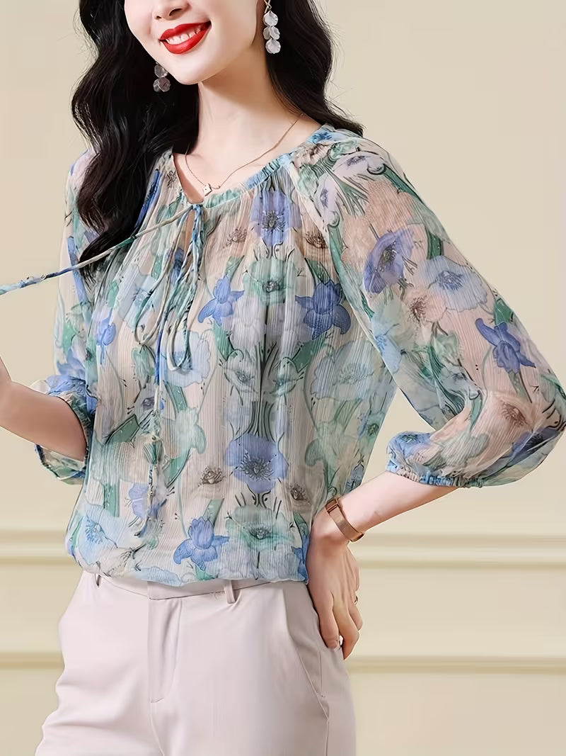 This ethereal Top features a delicate floral print in  of blue, green, and beige Top