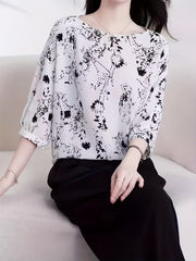 This modern Top features a refined black floral and abstract line print Top