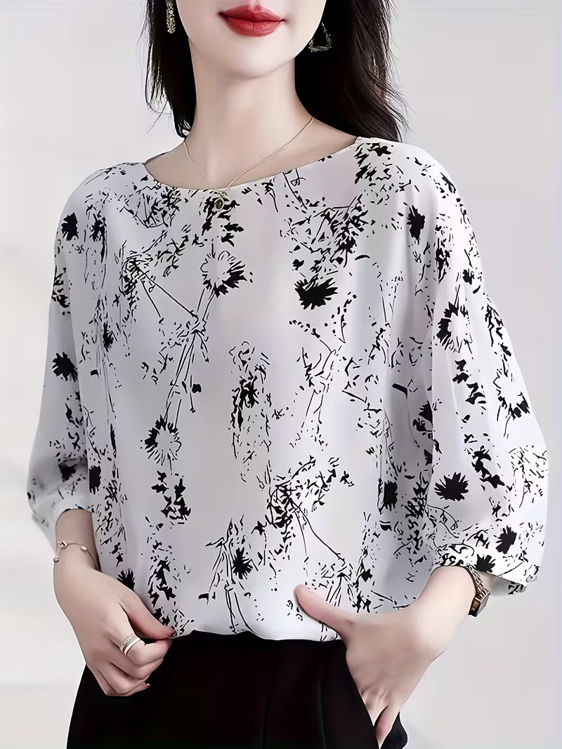 This modern Top features a refined black floral and abstract line print Top