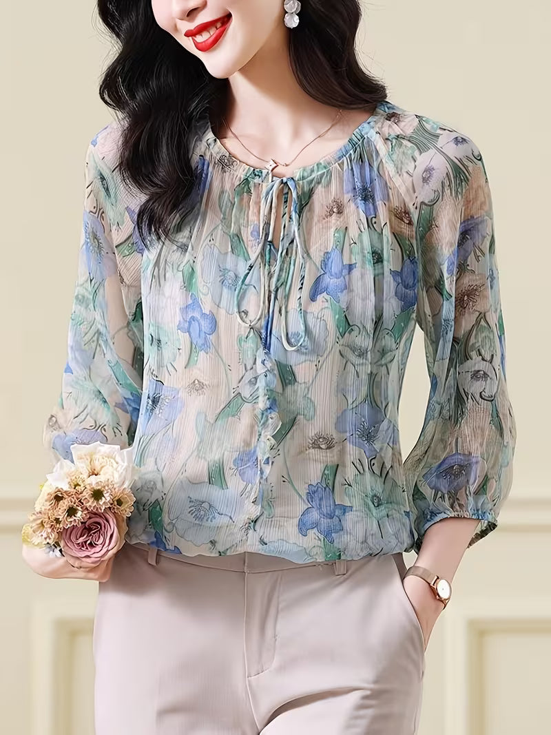 This ethereal Top features a delicate floral print in  of blue, green, and beige Top